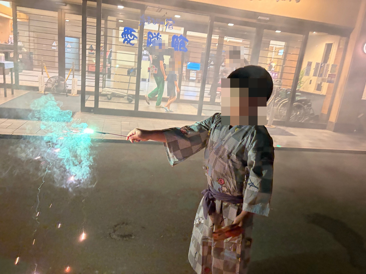 愛隣館の玄関を背景に手持ち花火を楽しむ様子