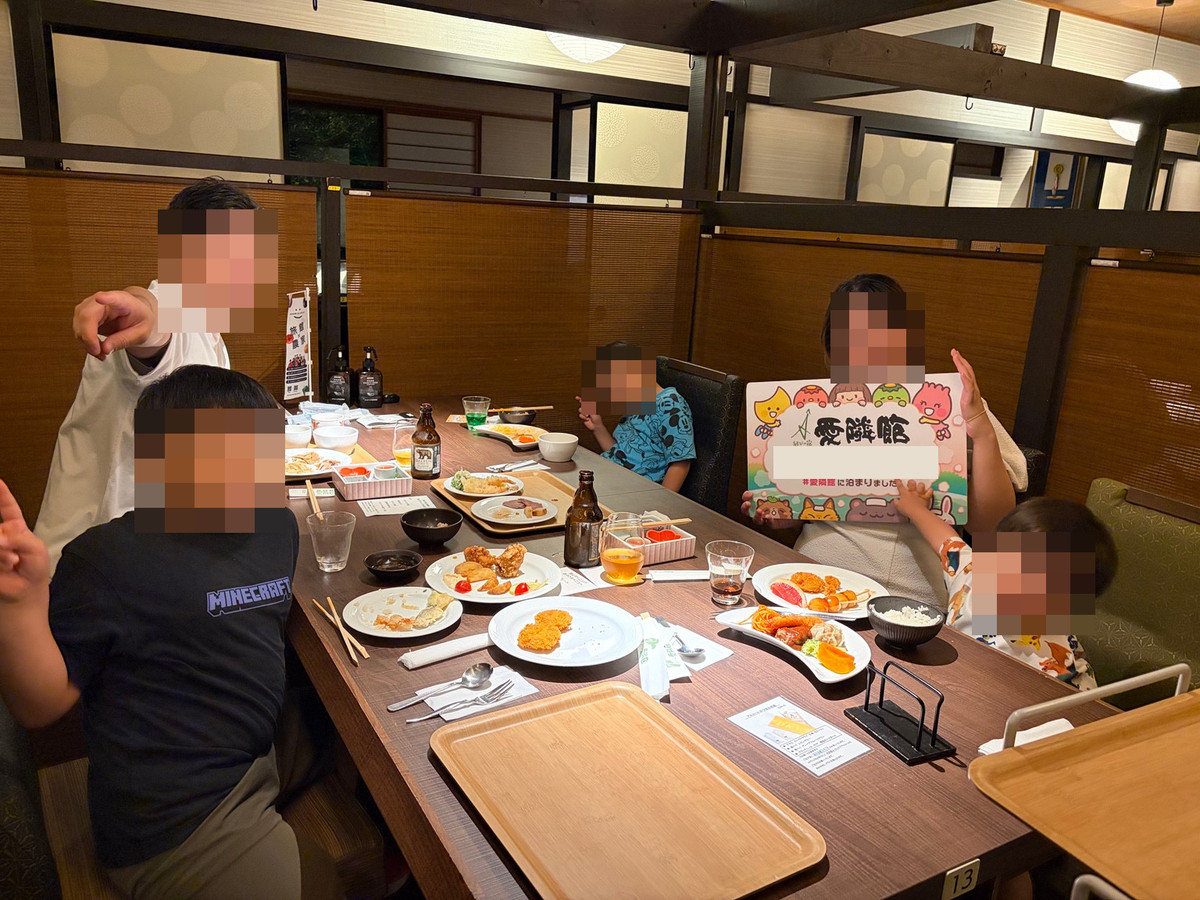 愛隣館の食事会場でテーブルを囲む家族