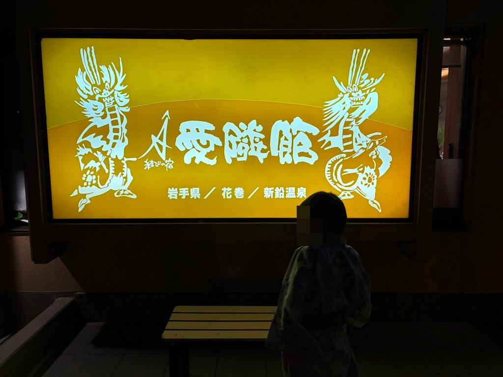 龍の絵と「結びの宿 愛隣館」「岩手県 花巻 新鉛温泉」の文字が入った看板